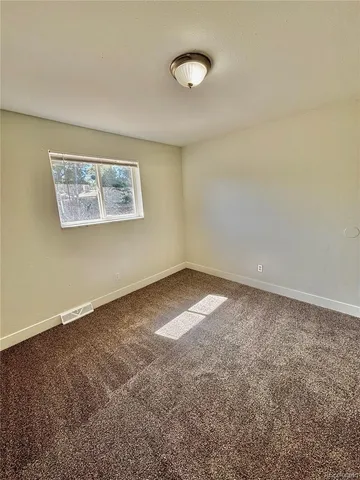 a view of a kitchen with refrigerator and wooden floor