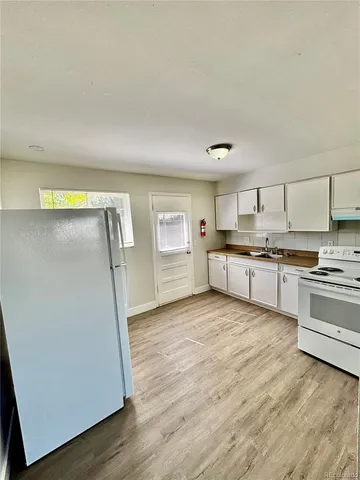 an empty room with wooden floor and white wall