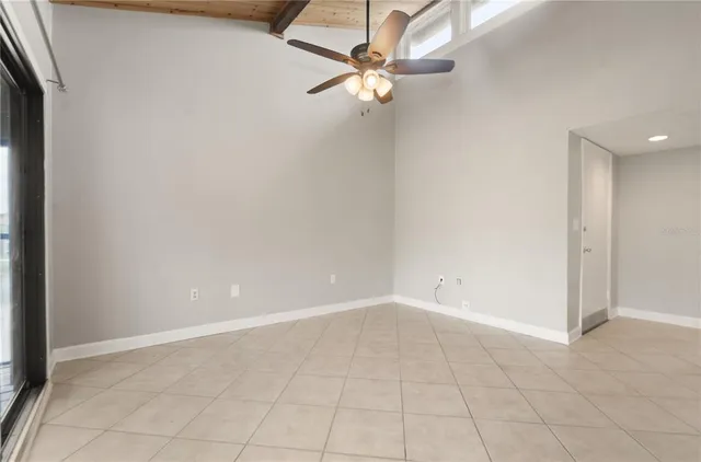 an empty room with white walls and fan