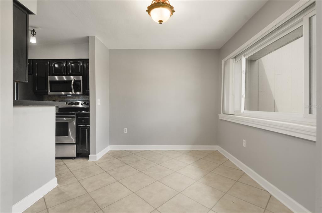 5929 Windhover Drive, Unit A02 Orlando, FL 32819 - Photo 8 of 17 a view of kitchen with microwave and cabinets