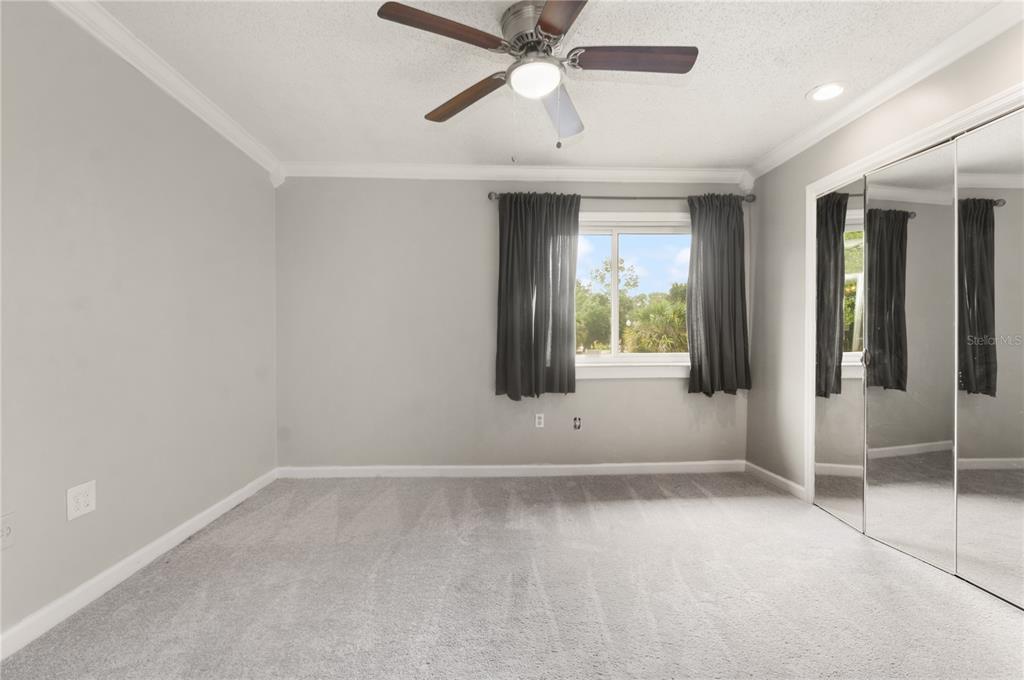 5929 Windhover Drive, Unit A02 Orlando, FL 32819 - Photo 9 of 17 an empty room with chandelier fan and windows