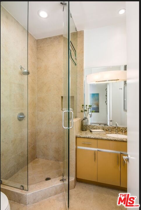 3685 Mandeville Canyon Road Los Angeles, CA 90049 - Photo 14 of 24 a bathroom with a shower sink and mirror