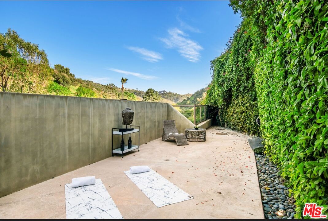 3685 Mandeville Canyon Road Los Angeles, CA 90049 - Photo 17 of 24 a view of a terrace with a bench