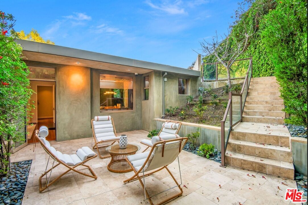 3685 Mandeville Canyon Road Los Angeles, CA 90049 - Photo 18 of 24 a view of a patio with couches table and chairs and potted plants
