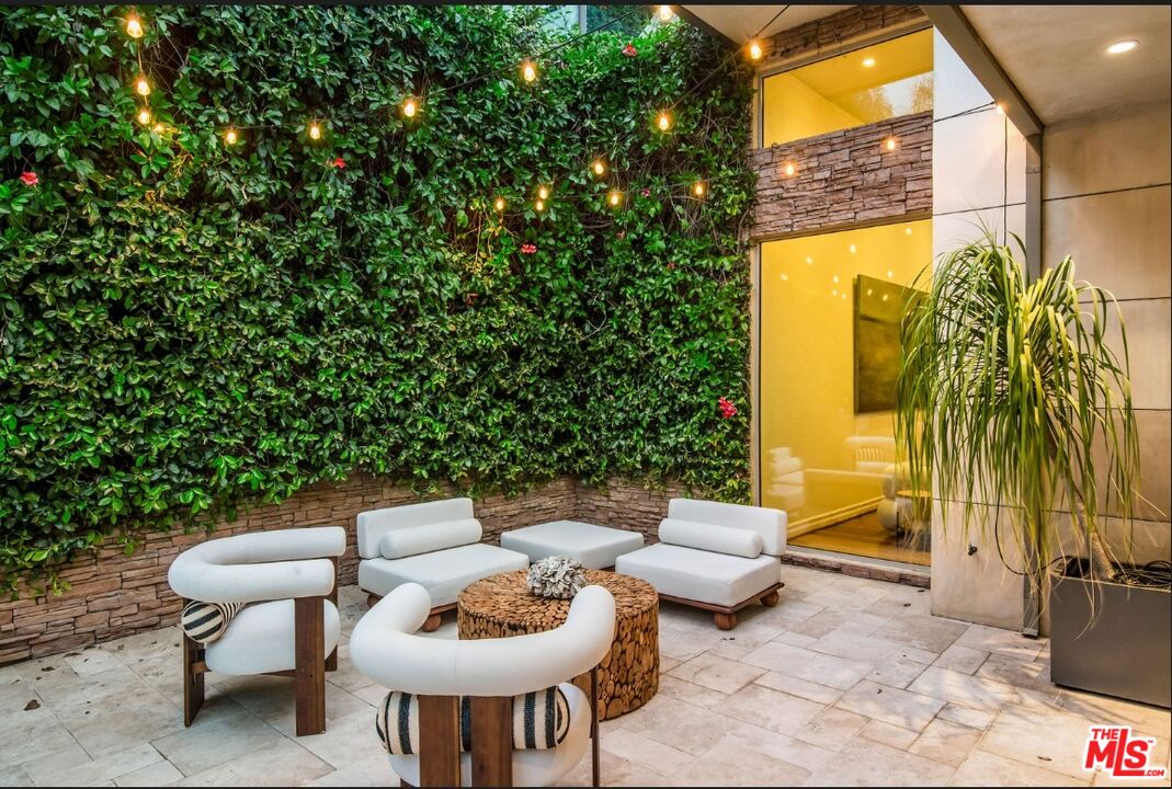 3685 Mandeville Canyon Road Los Angeles, CA 90049 - Photo 19 of 24 a backyard of a house with table and chairs