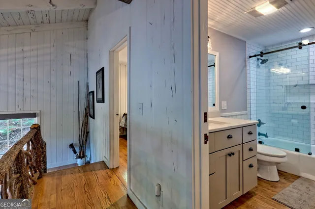 a view of a patio with table and chairs and couches with wooden floor and fence
