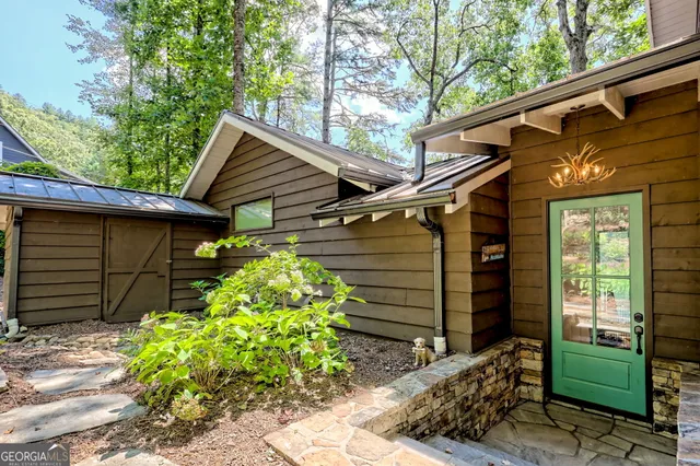 a backyard of a house with potted plants and a bench