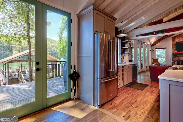 a kitchen with stainless steel appliances granite countertop a refrigerator and a wooden fence