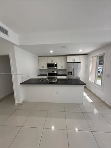 a view of kitchen with stainless steel appliances a sink and a counter top space