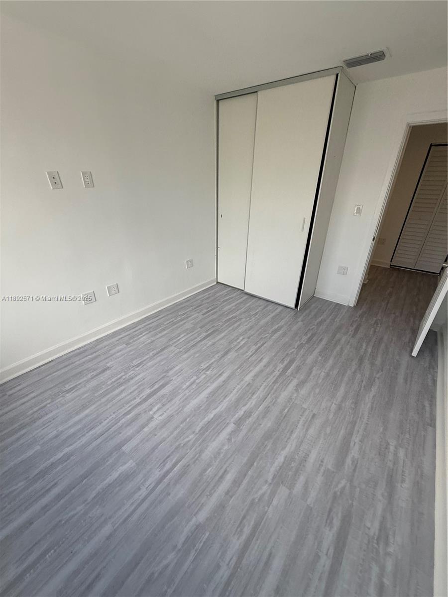 13984 Southwest 259th Street, Unit 13984 Homestead, FL 33032 - Photo 14 of 67 a view of an empty room with wooden floor