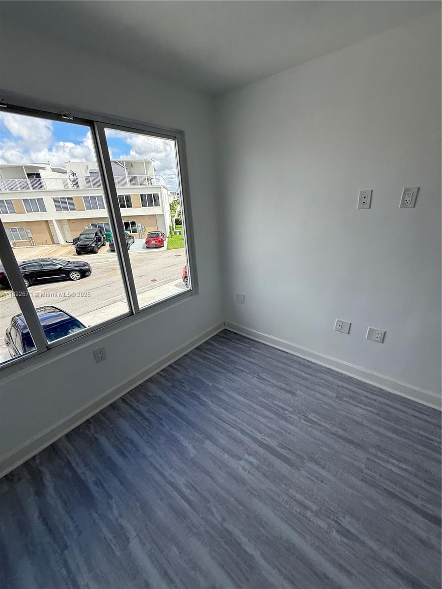 13984 Southwest 259th Street, Unit 13984 Homestead, FL 33032 - Photo 16 of 67 an empty room with wooden floor and windows