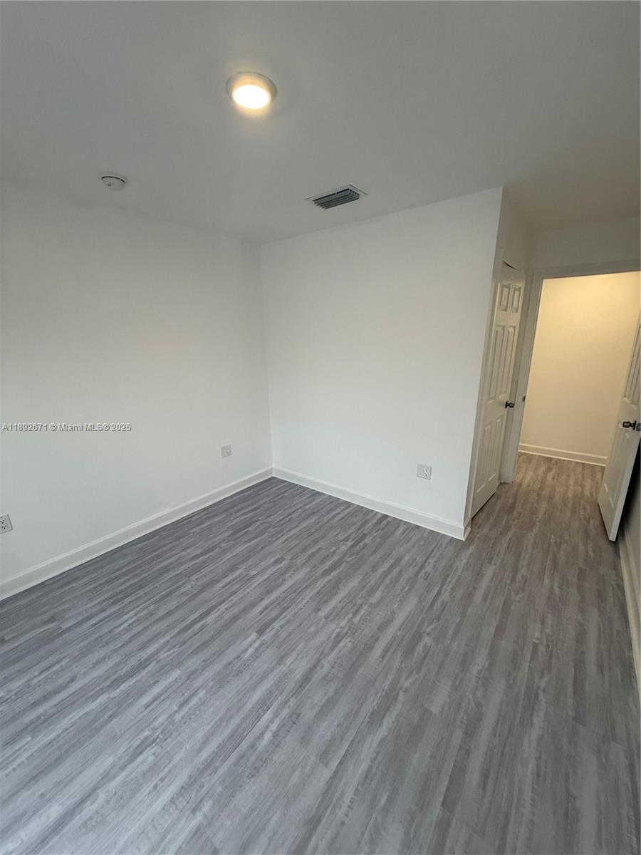 13984 Southwest 259th Street, Unit 13984 Homestead, FL 33032 - Photo 19 of 67 an empty room with wooden floor and windows