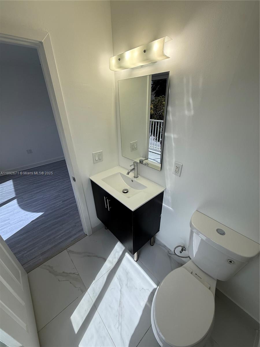 13984 Southwest 259th Street, Unit 13984 Homestead, FL 33032 - Photo 21 of 67 a bathroom with a toilet sink and mirror