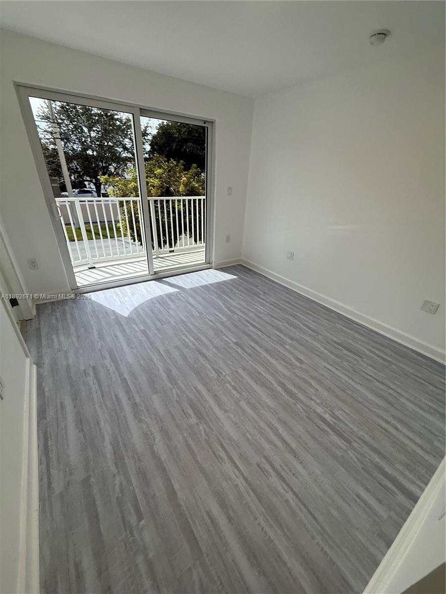 13984 Southwest 259th Street, Unit 13984 Homestead, FL 33032 - Photo 24 of 67 an empty room with wooden floor and windows