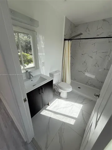 a room with a sink a toilet and mirror