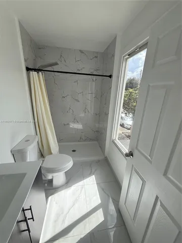 a bathroom with a toilet and a shower