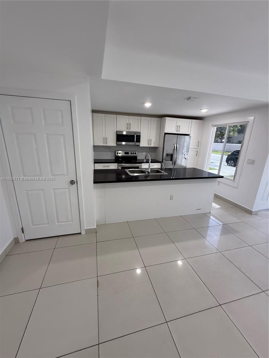 13984 Southwest 259th Street, Unit 13984 Homestead, FL 33032 - Photo 3 of 67 a kitchen with stainless steel appliances a sink stove and cabinets