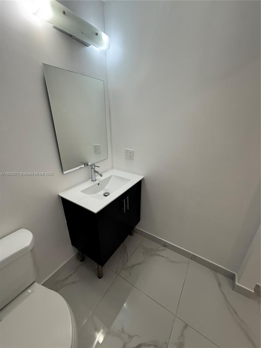 13984 Southwest 259th Street, Unit 13984 Homestead, FL 33032 - Photo 33 of 67 a room with a sink a toilet and mirror