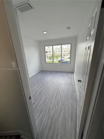 an empty room with wooden floor and white walls