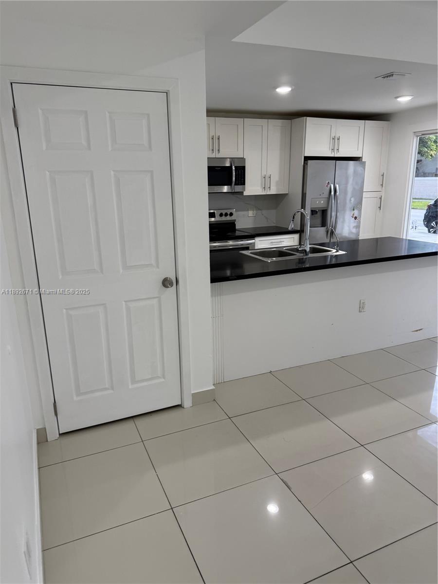 13984 Southwest 259th Street, Unit 13984 Homestead, FL 33032 - Photo 4 of 67 a kitchen with stainless steel appliances granite countertop a sink and cabinets