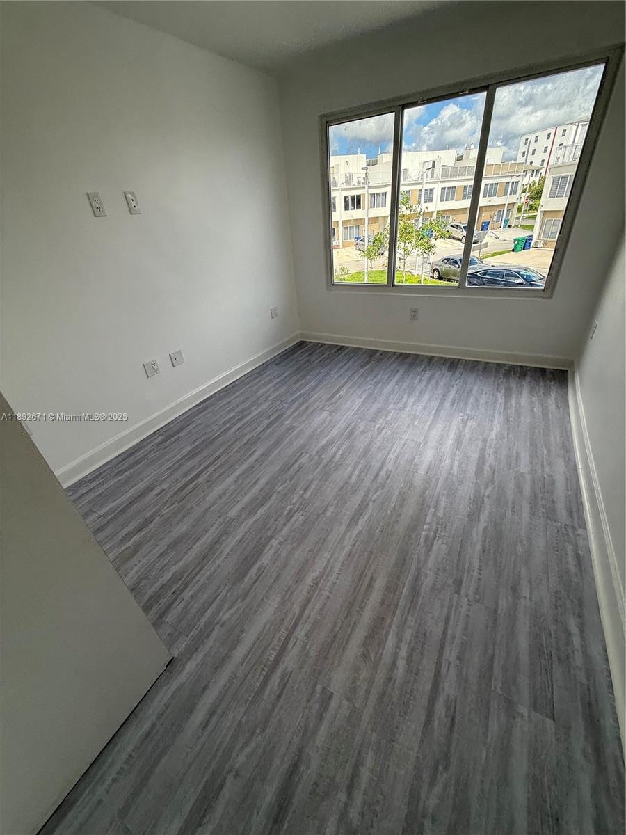 13984 Southwest 259th Street, Unit 13984 Homestead, FL 33032 - Photo 44 of 67 wooden floor in an empty room with a window