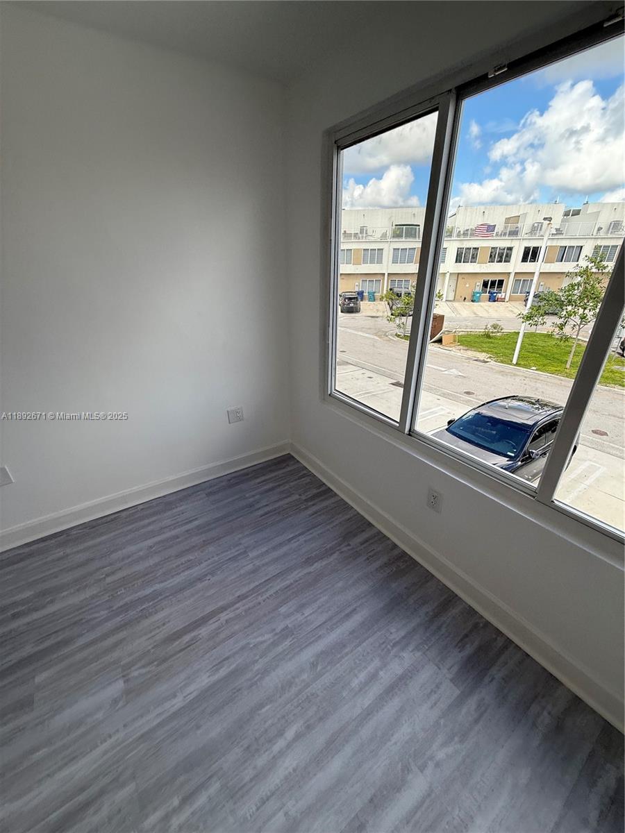13984 Southwest 259th Street, Unit 13984 Homestead, FL 33032 - Photo 45 of 67 a view of an empty room with wooden floor and a window