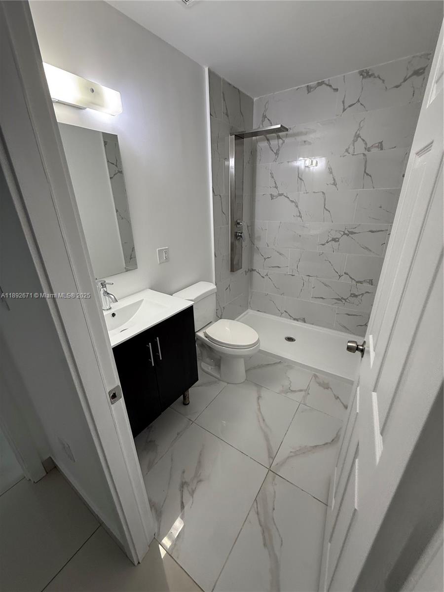 13984 Southwest 259th Street, Unit 13984 Homestead, FL 33032 - Photo 48 of 67 a bathroom with a double vanity sink toilet and shower