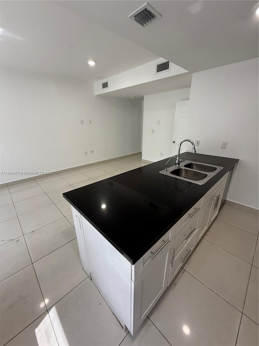 13984 Southwest 259th Street, Unit 13984 Homestead, FL 33032 - Photo 57 of 67 a kitchen with a sink and a stove top oven