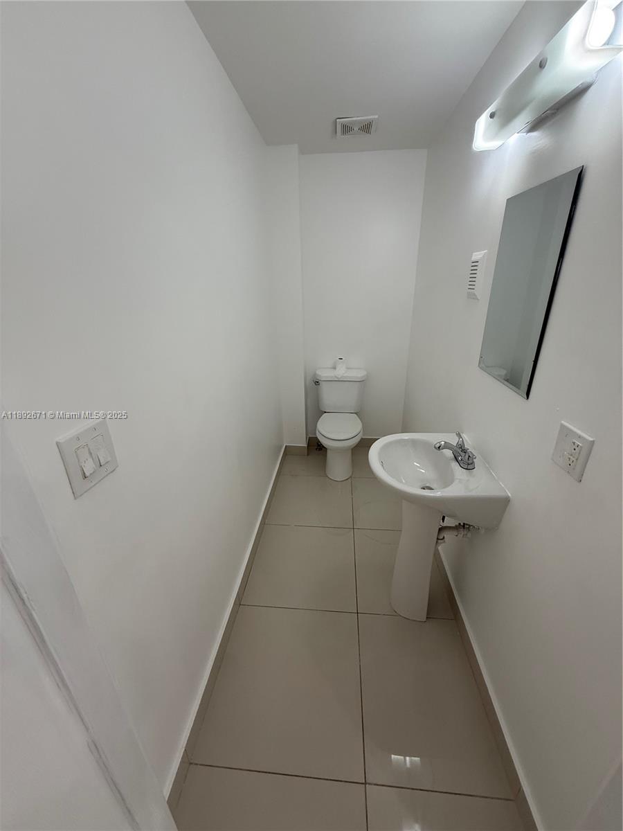 13984 Southwest 259th Street, Unit 13984 Homestead, FL 33032 - Photo 60 of 67 a bathroom with a sink toilet and a mirror