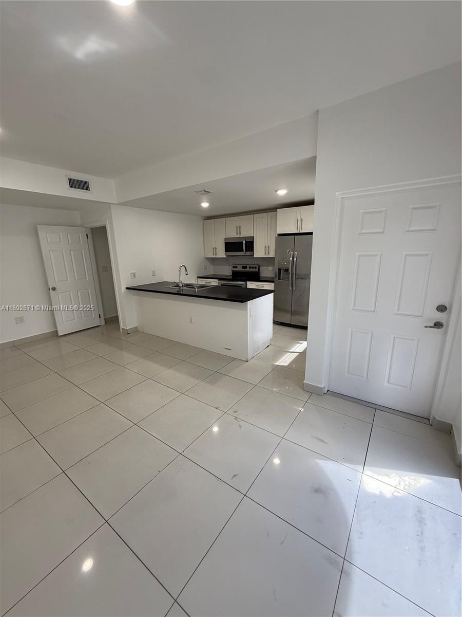 13984 Southwest 259th Street, Unit 13984 Homestead, FL 33032 - Photo 65 of 67 a kitchen with a sink a stove and cabinets