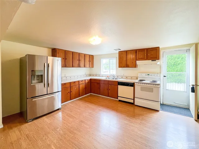 a kitchen with stainless steel appliances granite countertop a refrigerator and a stove top oven