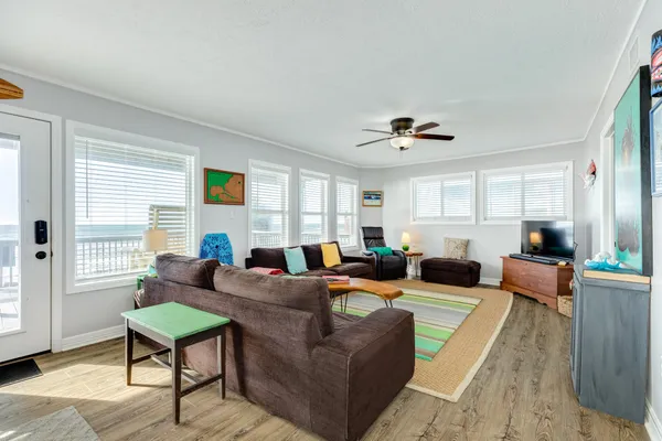 a living room with furniture ceiling fan and a window