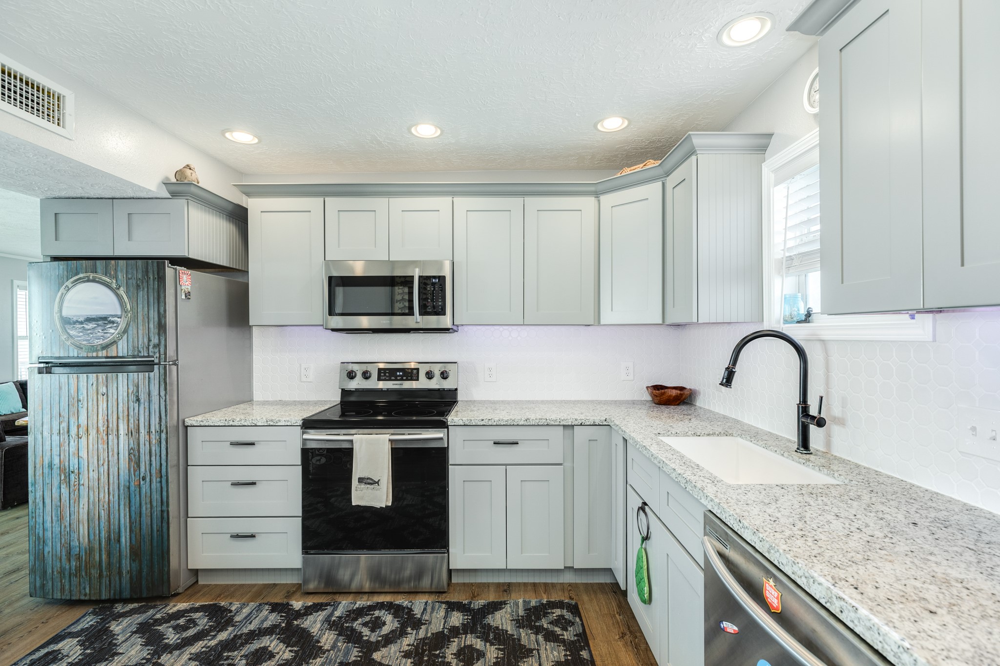 722 Beach Drive Surfside Beach, TX 77541 - Photo 14 of 34 a kitchen with stainless steel appliances granite countertop a stove a sink and a microwave