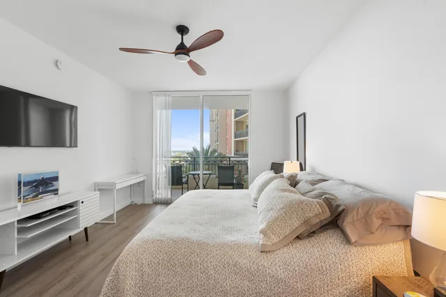a bedroom with a bed and a flat tv screen on dresser