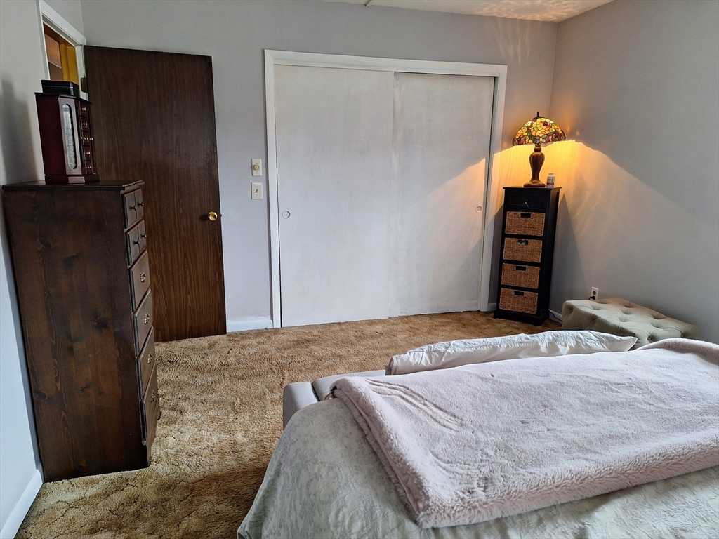 39 West Street, Unit B1 Randolph, MA 02368 - Photo 12 of 15 a bedroom with a bed and wooden floor