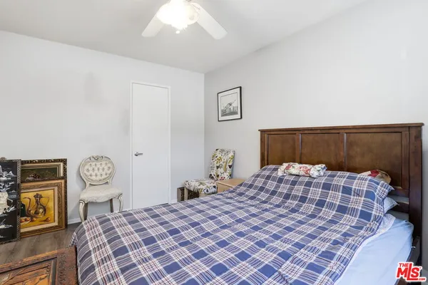 a bedroom with a bed a mirror on dresser and a chandelier