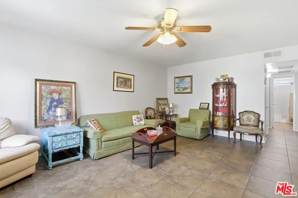 a living room with furniture and a view of kitchen