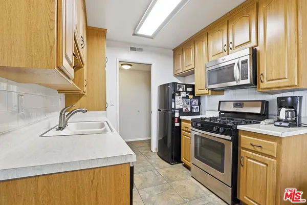 a kitchen with stainless steel appliances granite countertop a stove a sink and a refrigerator