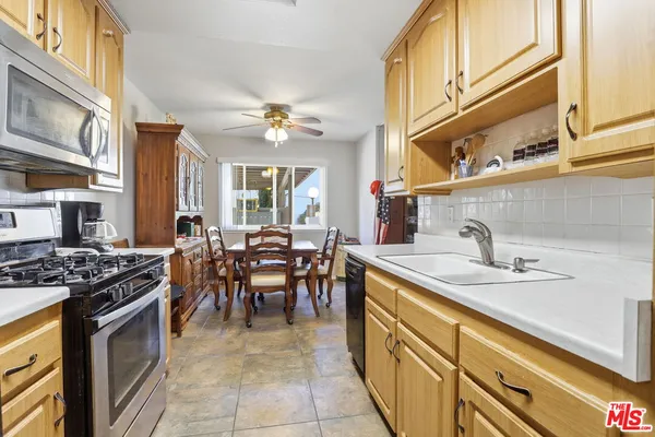 a kitchen with stainless steel appliances granite countertop a sink a stove and a refrigerator