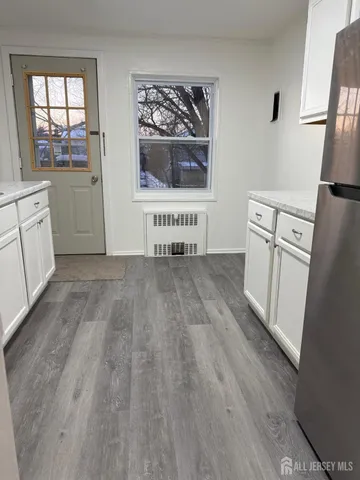 a kitchen with granite countertop white cabinets and white appliances