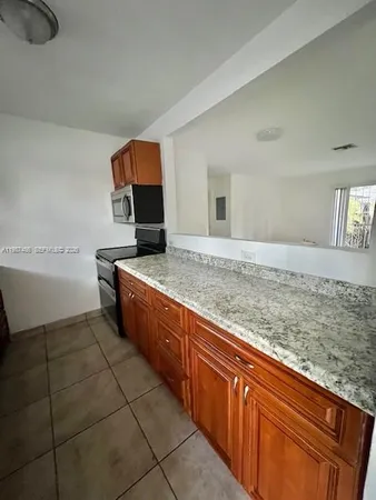 a kitchen with stainless steel appliances granite countertop a sink and cabinets
