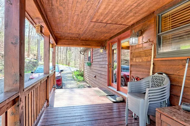 a view of a balcony with chairs and wooden floor