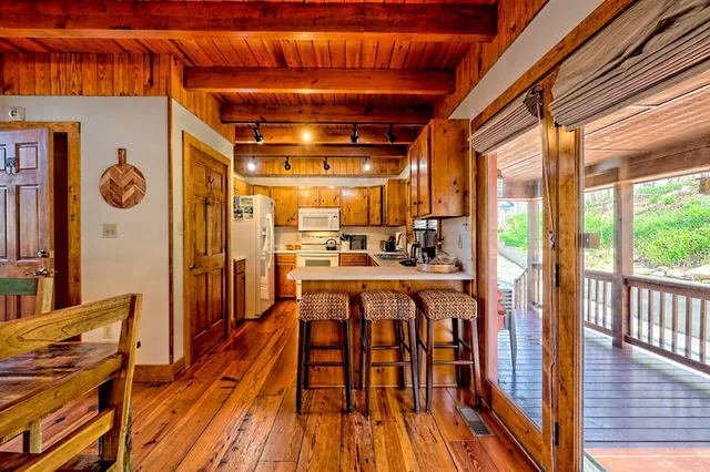 a living room with furniture a fireplace and large windows