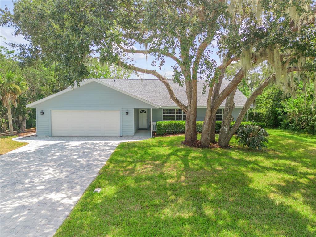 a view of a house with backyard and a tree