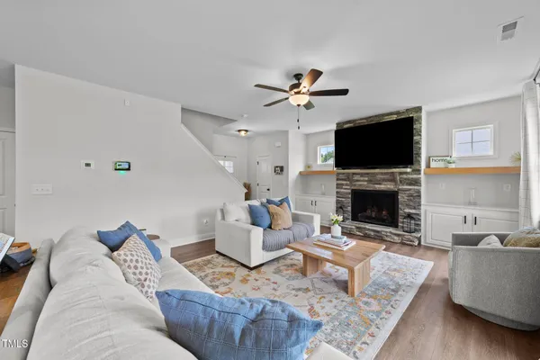 a living room with furniture a fireplace and a flat screen tv