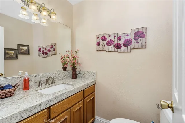 a bathroom with a granite countertop sink a mirror and vanity