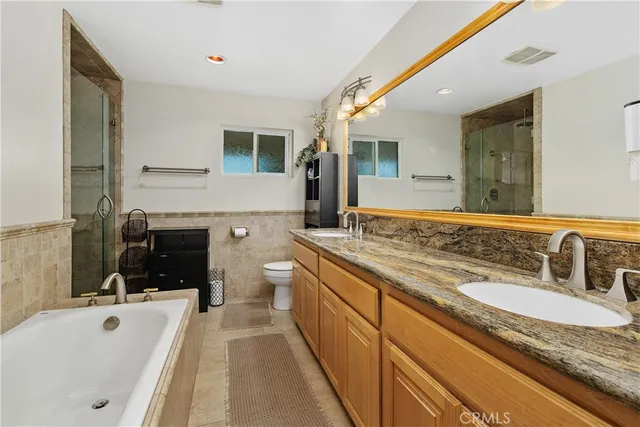 a spacious bathroom with a granite countertop tub sink and mirror