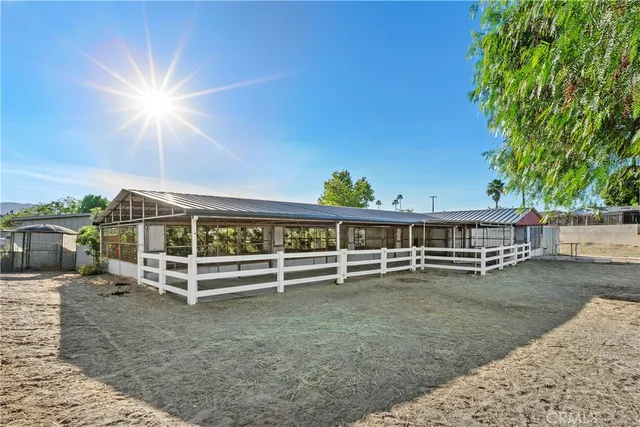 a view of a backyard with lawn chairs and iron fence