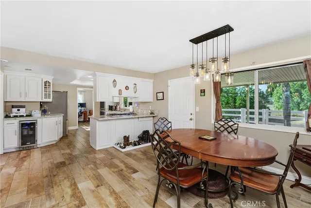 a kitchen with a dining table chairs and refrigerator