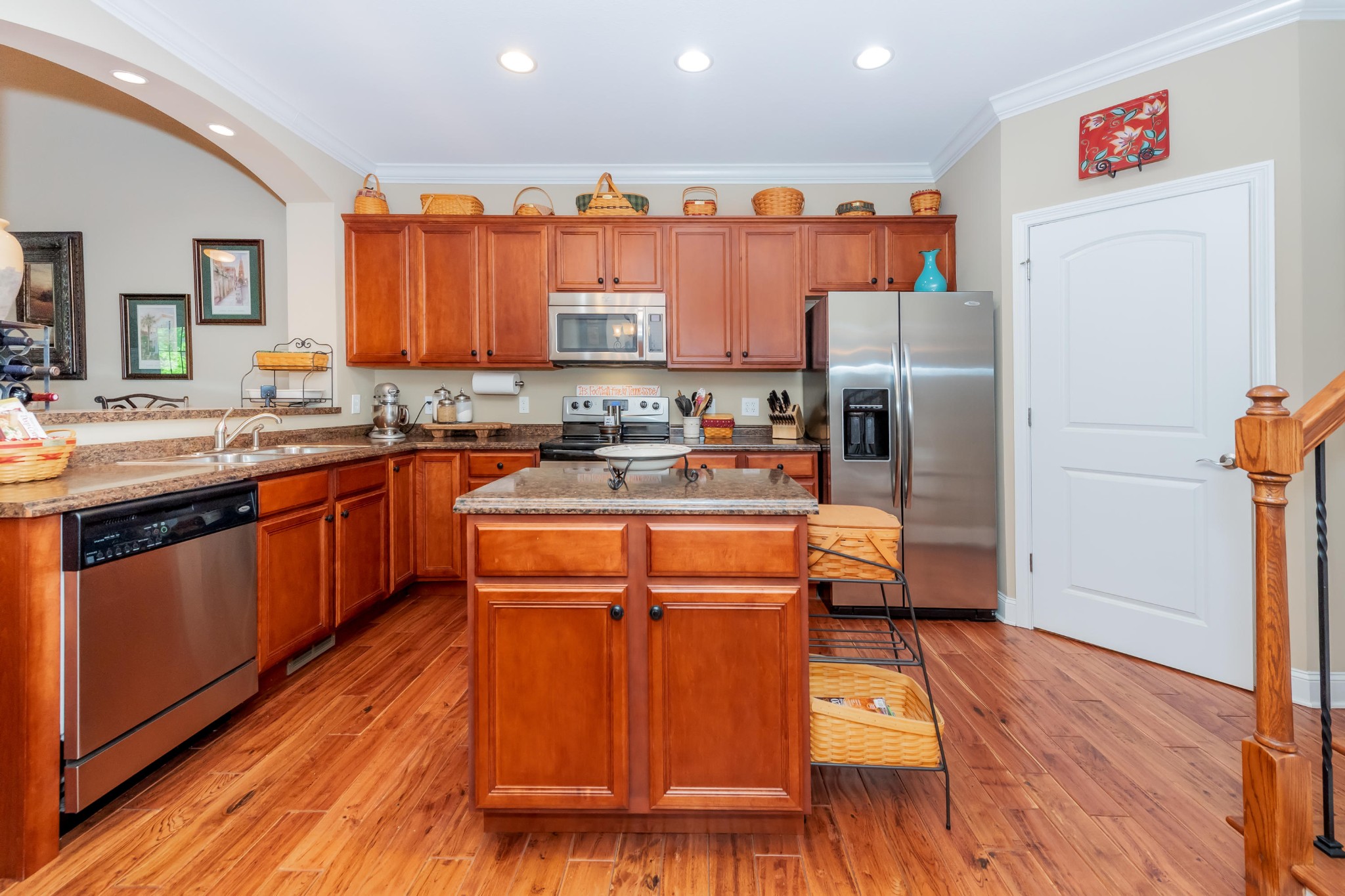 1833 Duncan Road, Unit 104 Knoxville, TN 37919 - Photo 6 of 36 a kitchen with stainless steel appliances granite countertop a refrigerator a sink dishwasher a stove with wooden cabinets and wooden floor